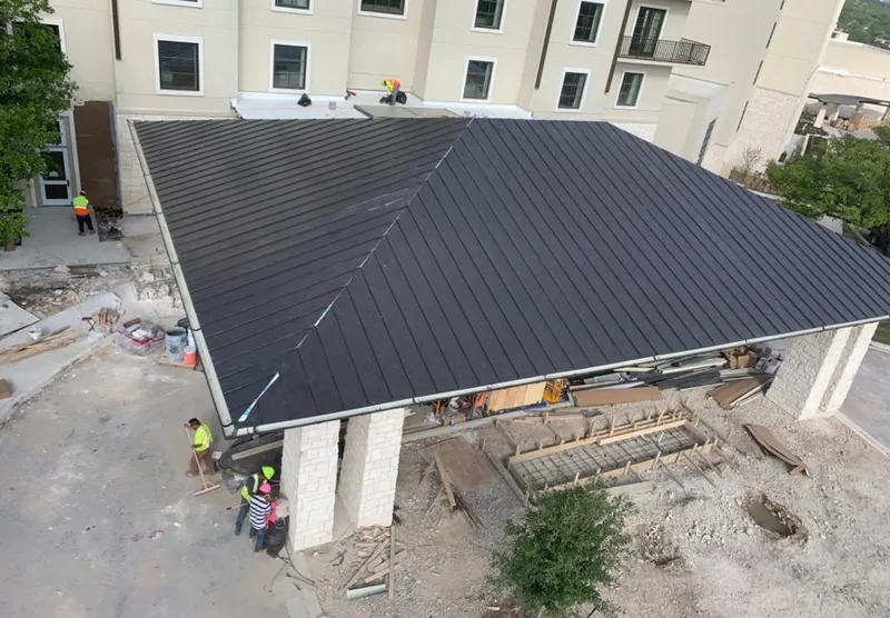 Metal roofing installation team working on a commercial building in Oak Forest
